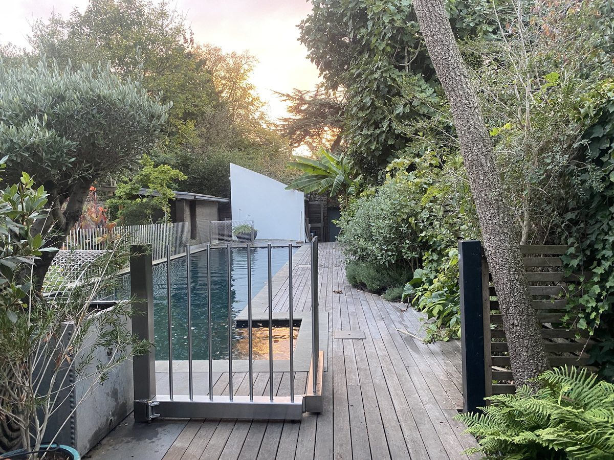 Finished bifold gate beside the pool